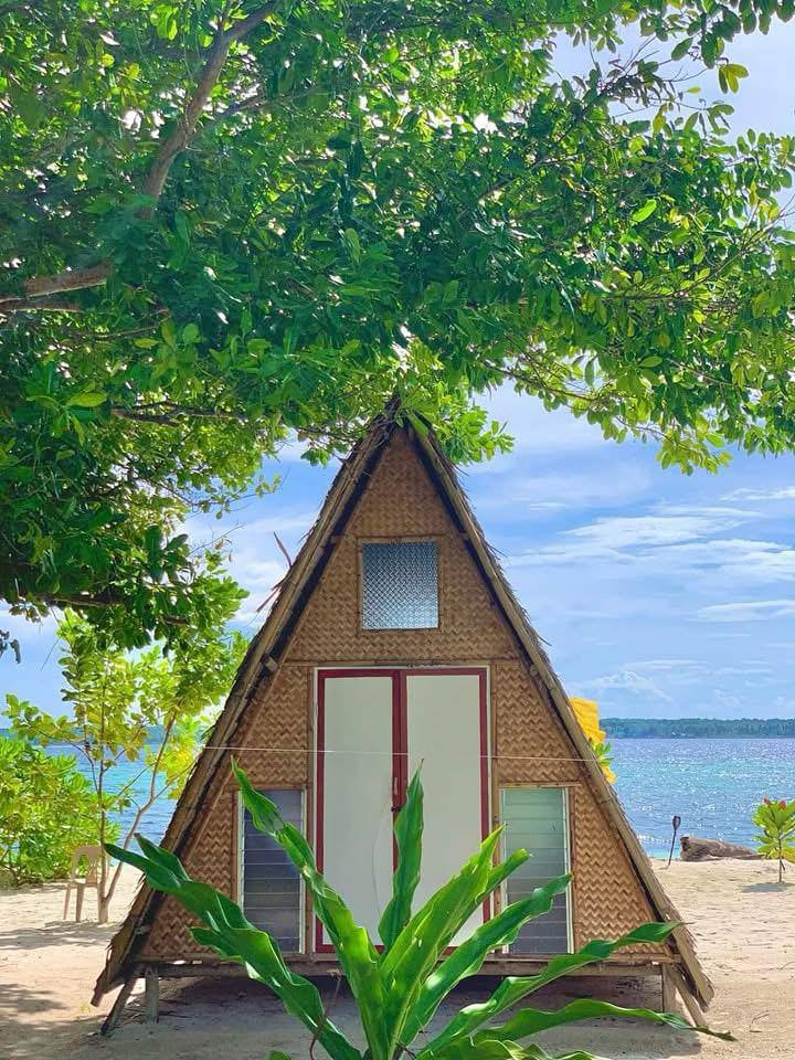 Beachfront native hut with a thatched roof at the shoreline
